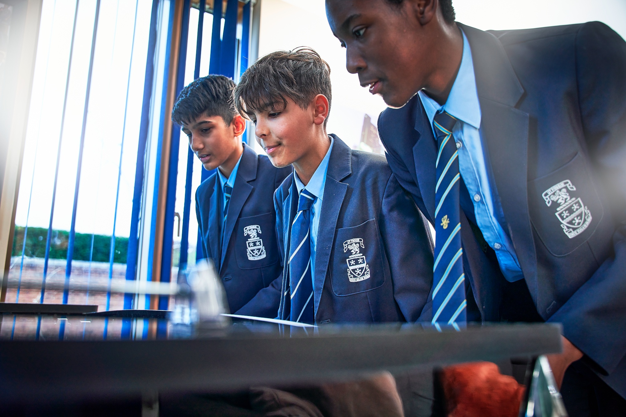 Three male students in the boarding house excitedly playing foosball