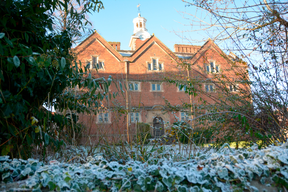 founders building covered in ice, with a wall in the foreground covered in frosted ivy