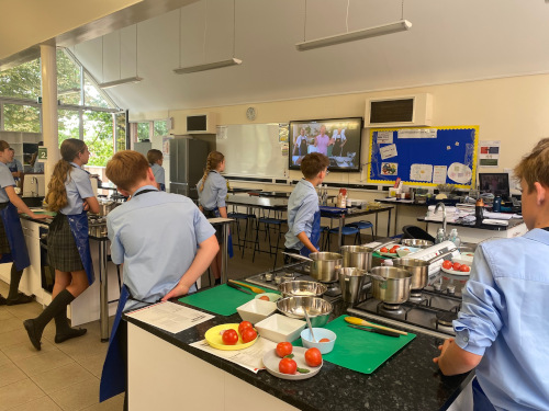 Students watching the live launch via Zoom with Jamie Oliver's team on the big screen at the front of the kitchen classroom
