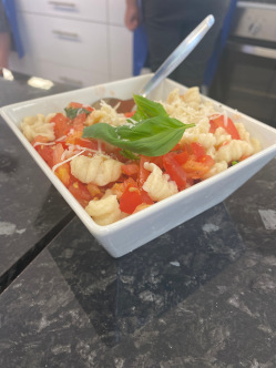 A bowl of fresh, homemade pasta with tomato sauce