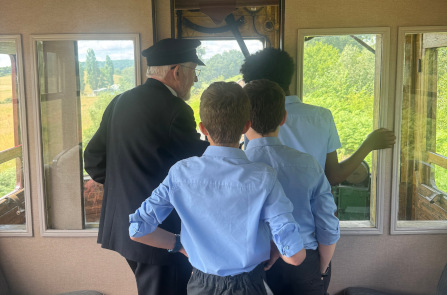 Students with a train driver looking out the front of a train