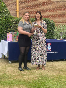 Sixth Form female student collects a trophy from Cat Eccles MP, shaking hands and smiling at the camera