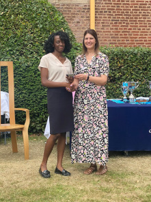 Sixth Form female student collects an award from Cat Eccles MP, shaking hands and smiling at the camera